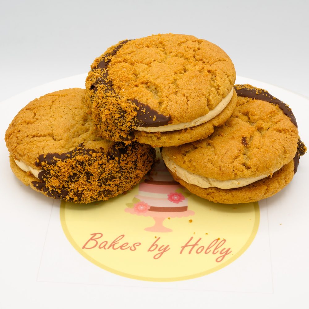 Three biscoff sandwich cookies dipped in chocolate with a biscoff cream filling