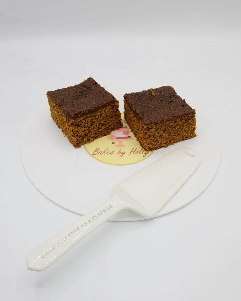 Two squares of sticky ginger parkin on a plate